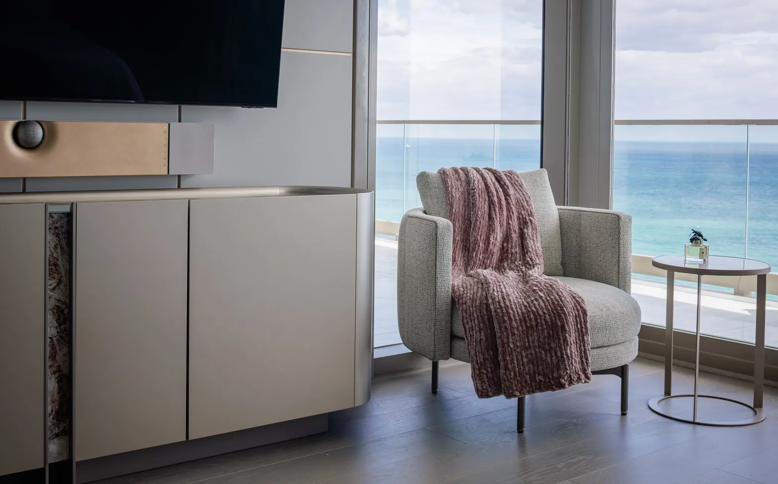 Master bedroom corner with textured armchair, curved sideboard and ocean view, Acqualina 2303, Sunny Isles Beach