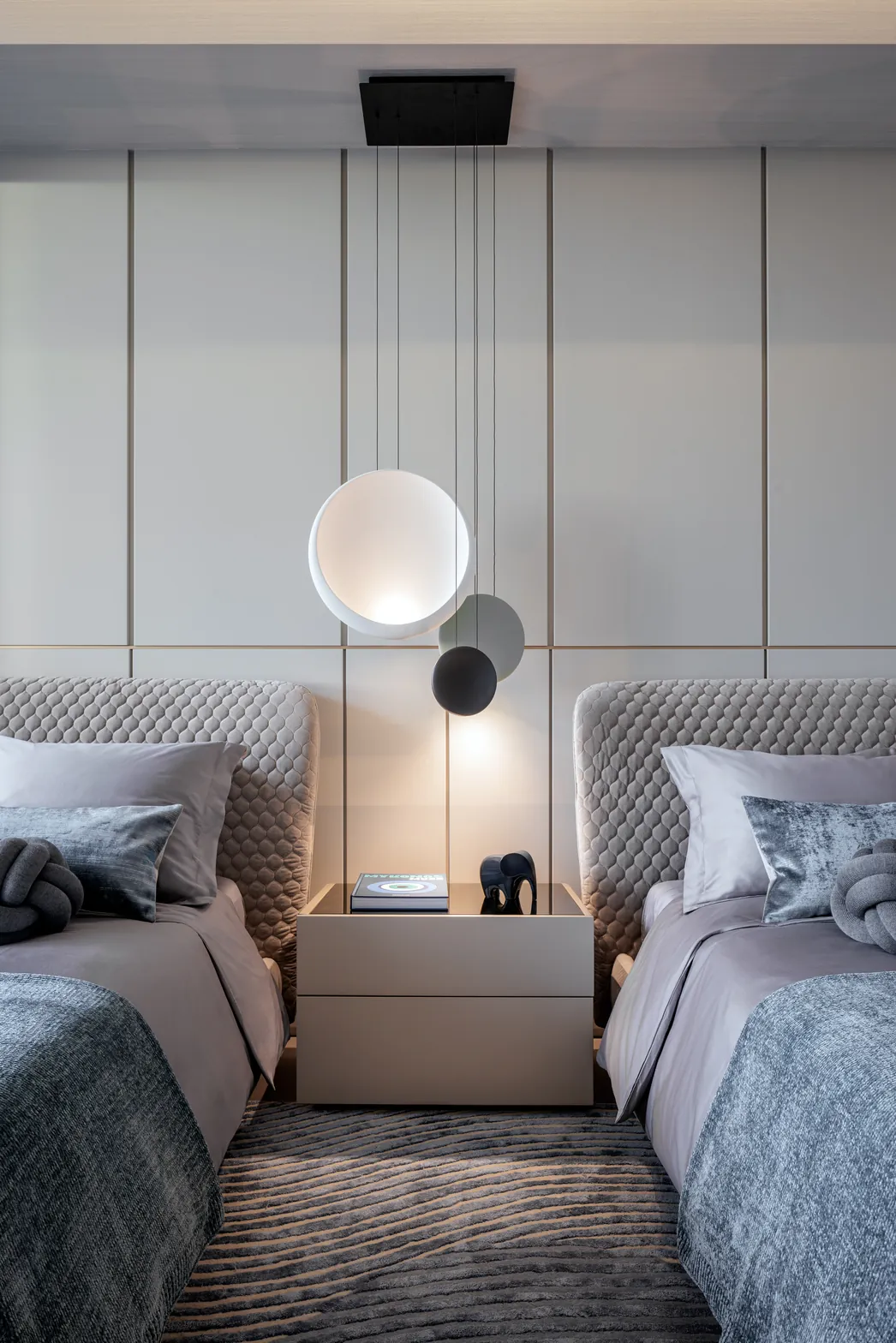 Boys' room detail with Vibia pendant between twin quilted headboards and wave-pattern rug, Acqualina 2303, Sunny Isles Beach